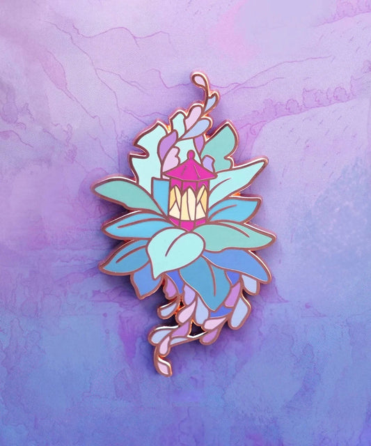 Enamel pin featuring a lantern and leaves design by Naomi VanDoren, showcasing intricate details and vibrant colors.