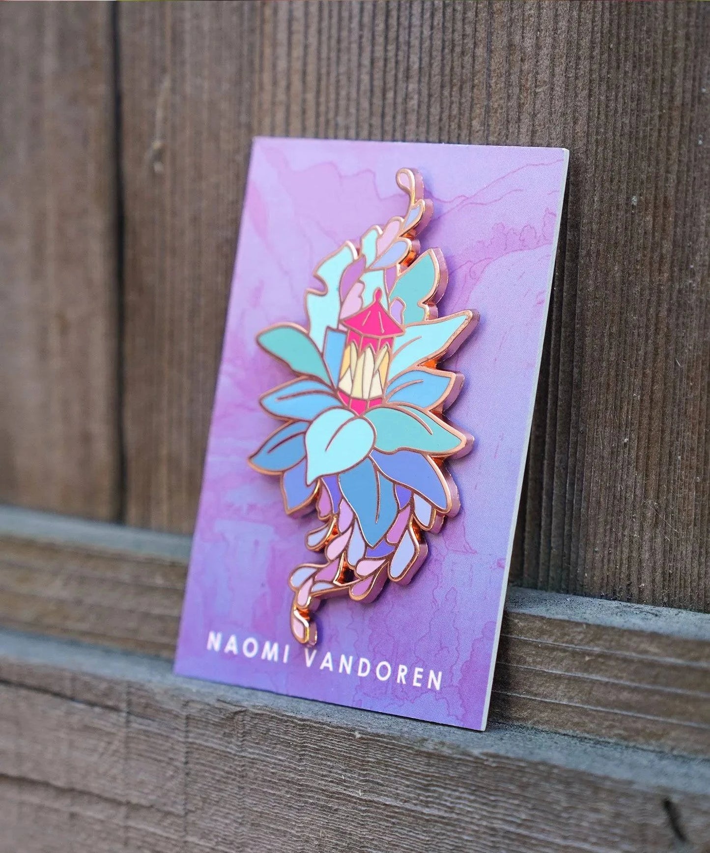 Enamel pin featuring a lantern and leaves design by Naomi VanDoren, perfect for adventure art and storytelling accessories.