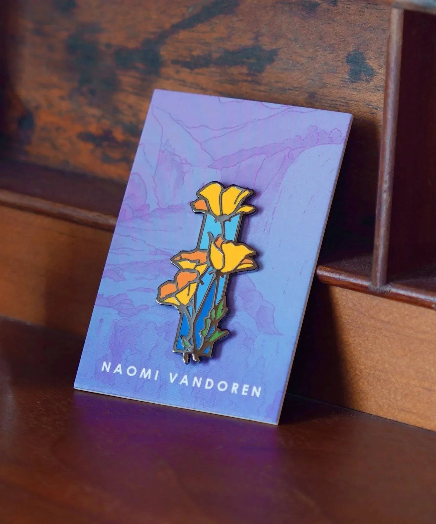 Bright enamel pin featuring vibrant red poppies by Naomi VanDoren, perfect for adding a colorful touch to clothing or accessories.