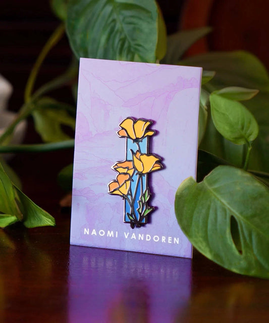 Colorful enamel pin featuring vibrant poppies by Naomi VanDoren, perfect for jackets or backpacks.