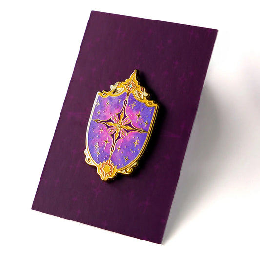 Celestial Armory Constellation Shield enamel pin by Naomi VanDoren featuring a starry shield design on a black background.