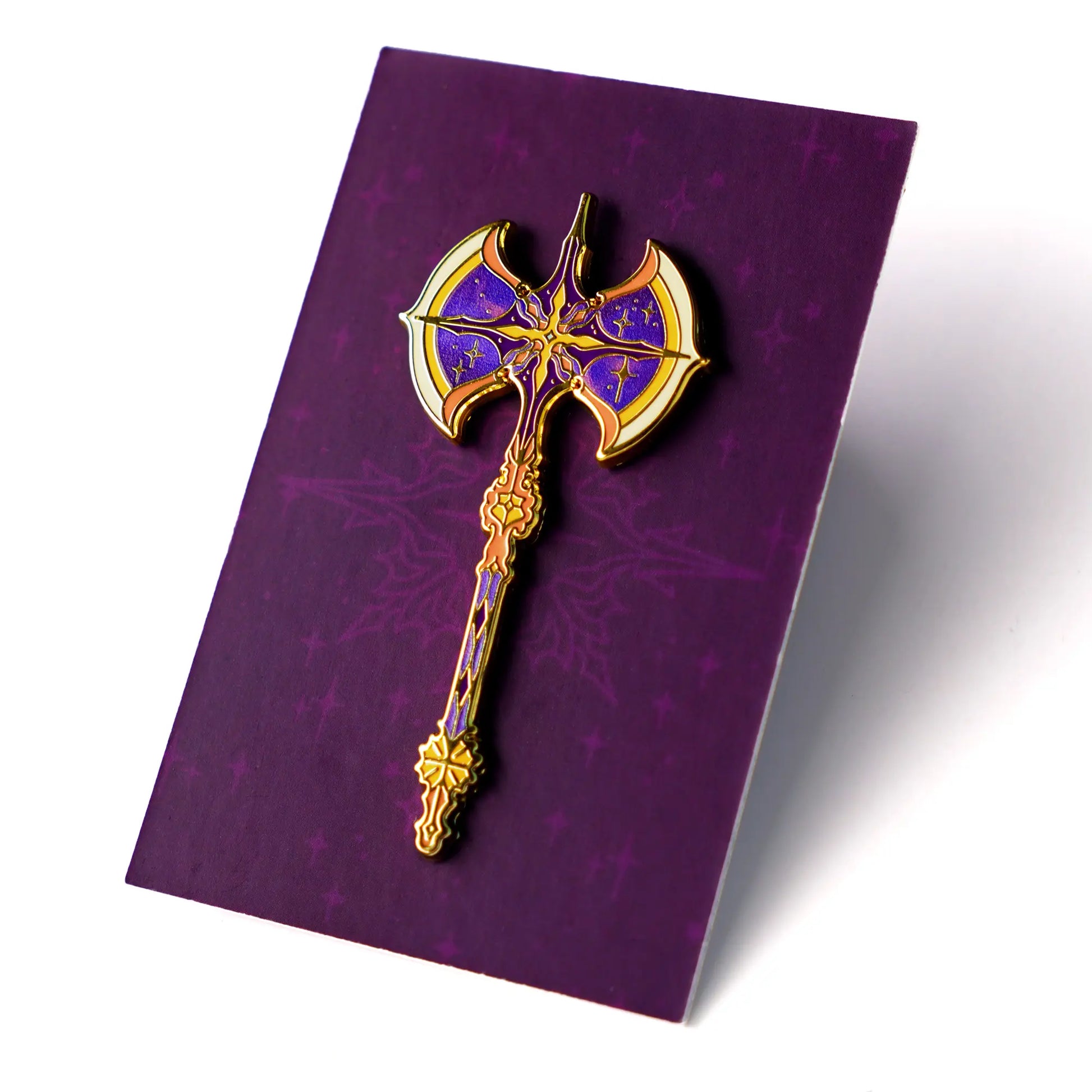 Celestial Armory Meteor Axe enamel pin by Naomi VanDoren featuring a detailed, space-inspired axe design on a black background.