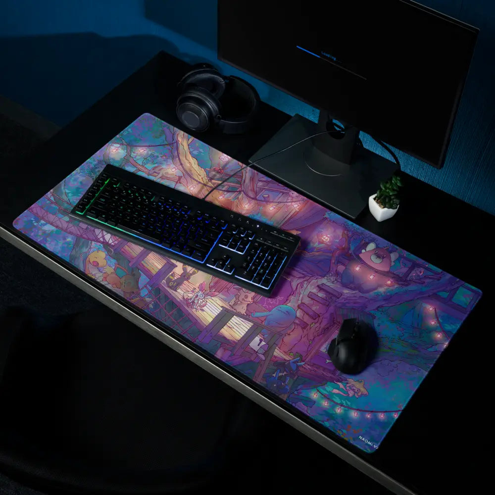 A large gaming desk mat with a colorful anime-style illustration, shown on a dark desk with a keyboard, mouse, and monitor nearby.