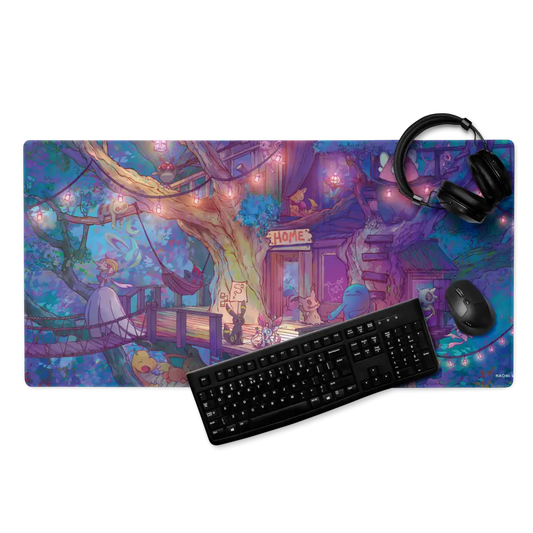 A large rectangular gaming desk mat with a colorful fantasy illustration, shown with a black keyboard, mouse, and over-ear headphones on a white background. The desk mat features a whimsical treehouse scene with purple, blue, pink, and yellow tones.