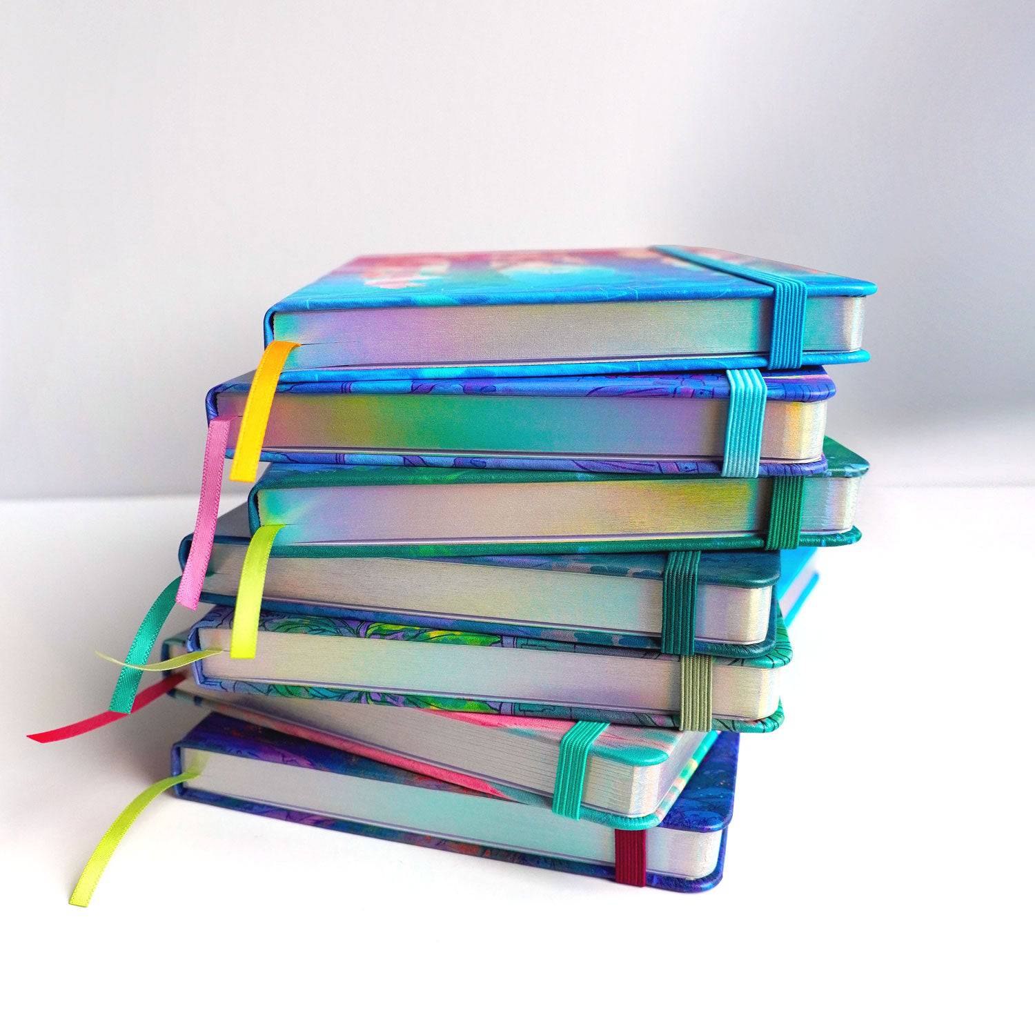 Stack of Naomi VanDoren's Gamer's Nook hardback notebooks featuring colorful adventure art and story designs.