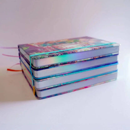 Hardback notebook by Naomi VanDoren from Cat Shop Apothecary with holographic pages, featuring an artistic and adventure-inspired design.